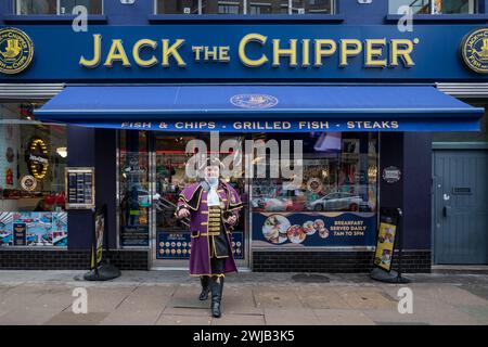 Londres, Royaume-Uni 14 février 2024. Un crieur de ville professionnel entièrement costumé, spécialement embauché le jour de la Saint-Valentin, attire les passants pour dîner à la boutique Jack the Chipper fish and chips à Whitechapel. Credit : Stephen Chung / Alamy Live News Banque D'Images