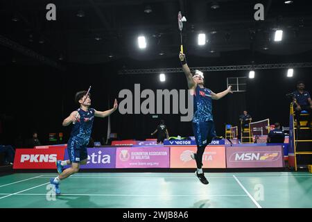 Shah Alam, Malaisie. 14 février 2024. Koga Akira (R)/Saito Taichi, du Japon, concourent dans le match de double contre NGE Joo Jie/Johann Prajogo, de Singapour, lors de la phase de groupes par équipes masculines aux Championnats d'Asie par équipes de Badminton 2024 à Shah Alam, Selangor, Malaisie, le 14 février 2024. Crédit : Chong Voon Chung/Xinhua/Alamy Live News Banque D'Images