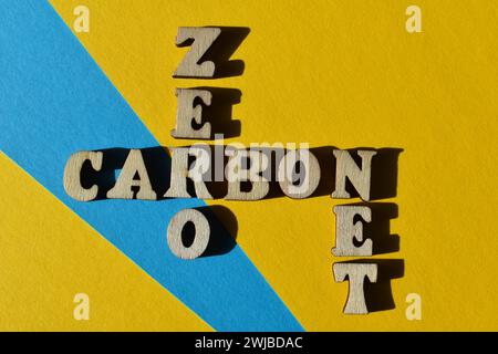 Net zéro carbone, mots en lettres de l'alphabet en bois sous forme de mots croisés isolés sur fond comme titre de bannière Banque D'Images