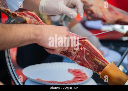 Maître de coupe de jambon, maître de couteau professionnel, Cortador de Jamon, homme coupant jambon placé dans un stand, gastronomie Banque D'Images