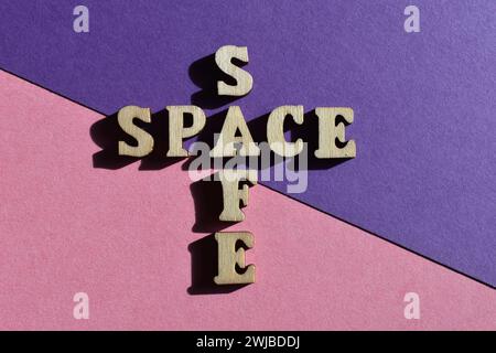Safe Space, mots en forme de mots croisés en lettres de l'alphabet en bois isolés sur fond rose et violet Banque D'Images