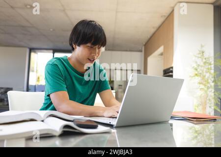 Adolescent asiatique étudiant intensément à la maison, avec espace de copie Banque D'Images