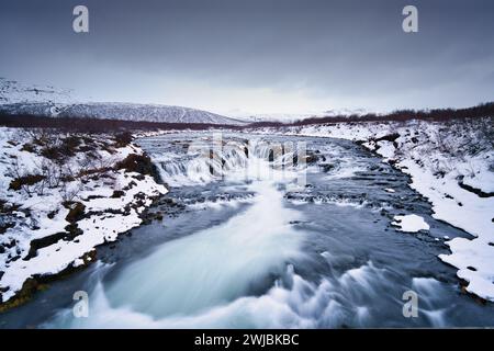 Cascade Bruarfoss en Islande prise comme une longue exposition pour mettre en évidence le débit de l'eau. Pris en hiver, la neige et la glace sont visibles à travers la scène. Banque D'Images