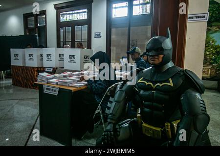 Bogor, Indonésie. 14 février 2024. Un fonctionnaire électoral portant le costume de super-héros Batman lors des élections présidentielles et législatives indonésiennes dans un bureau de vote à Bogor, Indonésie, le 14 février 2024. (Photo par Andi M Ridwan/INA photo Agency/SIPA USA) crédit : SIPA USA/Alamy Live News Banque D'Images