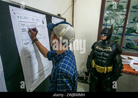 Bogor, Indonésie. 14 février 2024. Un fonctionnaire électoral portant le costume de super-héros Batman lors des élections présidentielles et législatives indonésiennes dans un bureau de vote à Bogor, Indonésie, le 14 février 2024. (Photo par Andi M Ridwan/INA photo Agency/SIPA USA) crédit : SIPA USA/Alamy Live News Banque D'Images