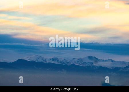 Vue aérienne d'un avion survolant des sommets enneigés Banque D'Images