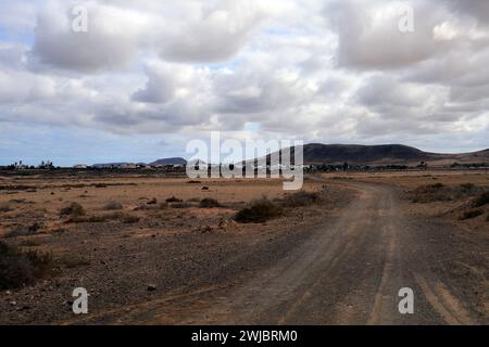 Route poussiéreuse vers le village d'El Roque à travers la brousse d'El Cotillo, Fuerteventura a pris novembre 2023 jour nuageux Banque D'Images