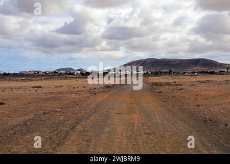 Route poussiéreuse vers le village d'El Roque à travers la brousse d'El Cotillo, Fuerteventura a pris novembre 2023 jour nuageux Banque D'Images