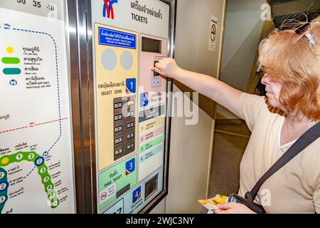 Bangkok, Thaïlande - 22 décembre 2009 : une femme achète un billet à la billetterie de la gare de Nana. Banque D'Images