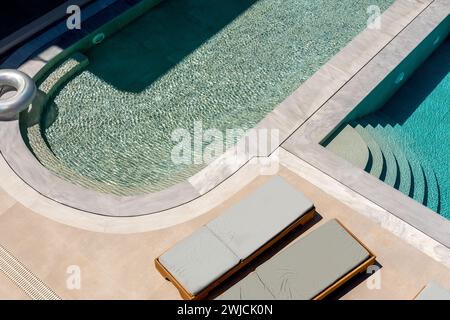 Vue de dessus de la piscine avec chaises longues. Arrière-plan estival. Banque D'Images