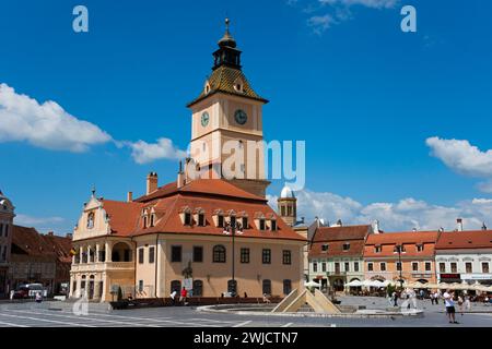 Place du marché par une journée ensoleillée avec bâtiment historique avec horloge de tour et des gens détendus, ancien hôtel de ville sur la place du marché Piata Sfatului, vieille ville Banque D'Images