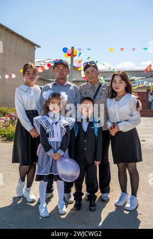 Famille et écolier le premier jour d'école, région d'Issyk-Koul, Kirghizistan Banque D'Images
