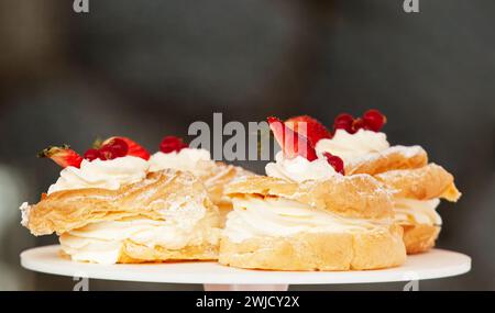 Gros plan de couronnes avec de la crème de jaune d'oeuf, de la crème fouettée et des fraises fraîches au marché des agriculteurs de rue dans le centre-ville de Prague, en République tchèque. Banque D'Images