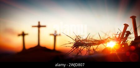 Crucifixion Calvary - Couronne d'épines et pics sanglants au coucher du soleil avec des croix défocalisées sur Hill et Flare Lights effets Banque D'Images