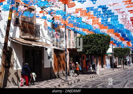 Des drapeaux picado en papier papel décorent la principale rue commerçante touristique de Calle Ezequiel Montes dans le quartier historique de Tequisquiapan, Querétaro, Mexique. Banque D'Images