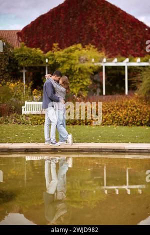 Jeune couple s'embrassant et se réjouissant au lac. charmant jeune couple s'embrassant dehors en automne. Couple amoureux marchant dans la nature. Ambiance automnale. Homme heureux Banque D'Images