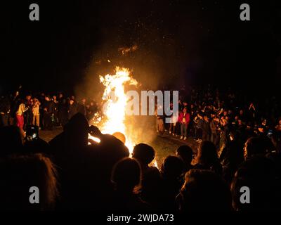 Madrid, Espagne. 14 février 2024. Les gens autour du feu de joie terminant la période du carnaval à Madrid. La « sépulture de la sardine » est un défilé funéraire célébré le mercredi des cendres afin de mettre fin à la célébration du carnaval à Madrid. Cette célébration païenne a été documentée par Goya dans une de ses peintures. © Valentin Sama-Rojo/Alamy Live News. Banque D'Images