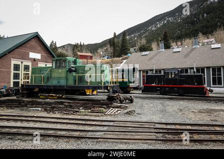 Vue de côté des manœuvres de locomotive diesel du chemin de fer de boucle de Georgetown dans le Colorado, États-Unis. Les moteurs sont garés dans un dépôt, regardant du profil bas. Banque D'Images