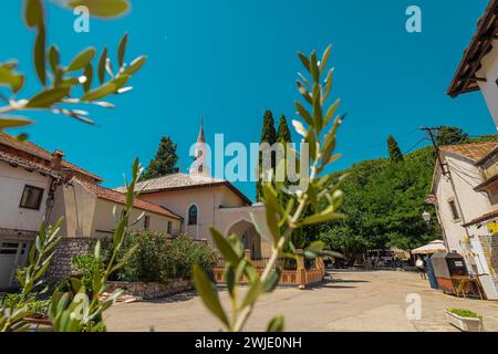 Mosquée d'osman pacha dans le centre de Trebinje, vue d'une place derrière quelques arbres. Belle journée ensoleillée avec un ciel bleu. Banque D'Images