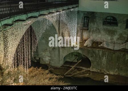 Célèbre pont capucinski ou kapucinski, un pont de pierre dans le centre de Skofja Loka, Slovénie par une nuit sombre. Pont montant sur la rivière Selska Sora. Banque D'Images