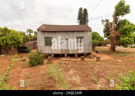 Ancienne maison revêtue de zinc de construction précaire élevée sur des fondations sur pilotis, composée de piliers en briques de terre construits au Mozambique Banque D'Images