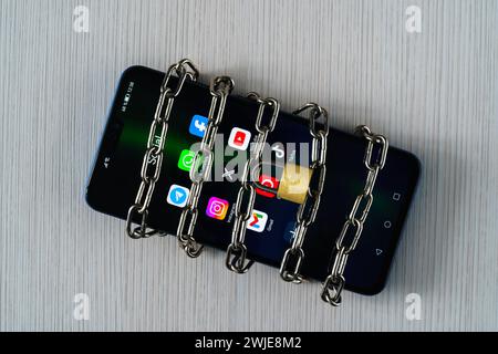 Ouzbékistan, Tachkent - 27 janvier 2024 : chaîne sur un téléphone mobile avec des icônes de réseau social sur elle. Le concept de limitation du temps sur les réseaux sociaux, Banque D'Images