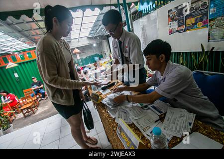 Fonctionnaires électoraux portant des uniformes d'école secondaire dans un bureau de vote, lors des élections générales à Bogor, Indonésie, le 14 février 2024 Banque D'Images