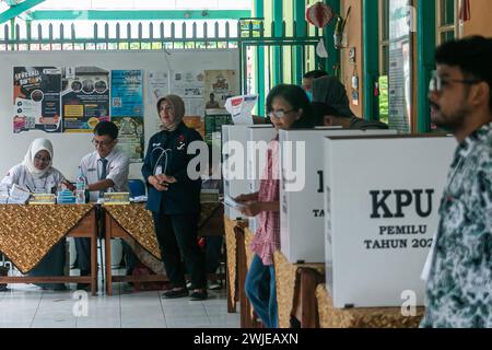 Fonctionnaires électoraux portant des uniformes d'école secondaire dans un bureau de vote, lors des élections générales à Bogor, Indonésie, le 14 février 2024 Banque D'Images