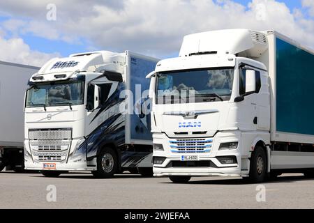 Nouveaux camions Volvo FH et MAN TGX personnalisés devant des remorques FRC à température contrôlée stationnées sur un chantier. Salo, Finlande. 25 juin 2023. Banque D'Images