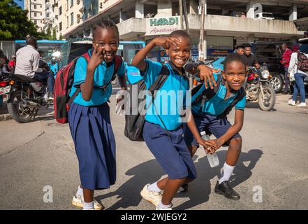 Une jeune fille et deux jeunes garçons en uniforme scolaire qui rentrent de l’école à Dar es Salaam, en Tanzanie Banque D'Images