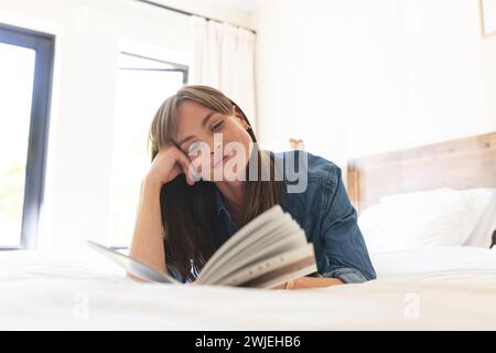Femme aime lire dans une chambre ensoleillée et confortable. Banque D'Images