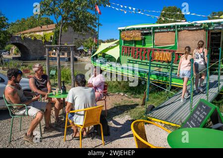 Canal du midi au pont et village du Somail Aude Sud de la France voies navigables méridionales les vacanciers font la queue pour une balade en bateau sur la rivière, FR Banque D'Images