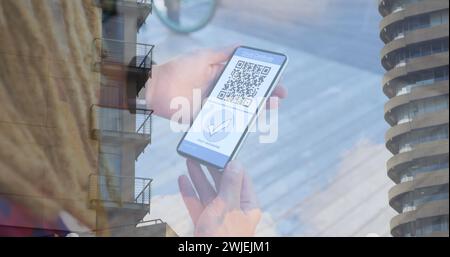 Image d'une femme tenant un smartphone avec passeport de vaccination covid 19 au-dessus du paysage urbain Banque D'Images