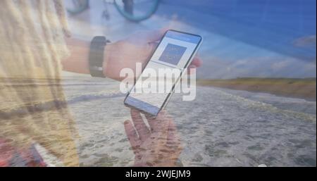 Composition de femme tenant un smartphone avec qr code sur l'écran contre vue aérienne de la plage Banque D'Images