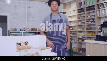 Jeune homme afro-américain se tient confiant dans une boulangerie, avec un espace de copie Banque D'Images