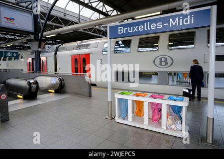 Belgique, Bruxelles : gare de Bruxelles-Sud. Réceptacle pour la collecte séparée de déchets sous un panneau Banque D'Images