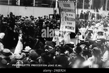 Procession des suffragettes, 17 juin 1911. Londres, Royaume-Uni. Carte postale photographique, imprimée, papier, monochrome, procédé de suffragette pris d'en haut, Christabel Pankhurst dans une robe blanche et des robes académiques marchant devant une bannière «690 EMPRISONNEMENTS POUR GAGNER LA LIBERTÉ POUR LES FEMMES», Banque D'Images