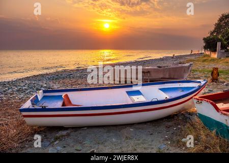 Le soleil levant illumine les bateaux sur les rives de la mer Égée. Platamonas, Pieria, Grèce Banque D'Images