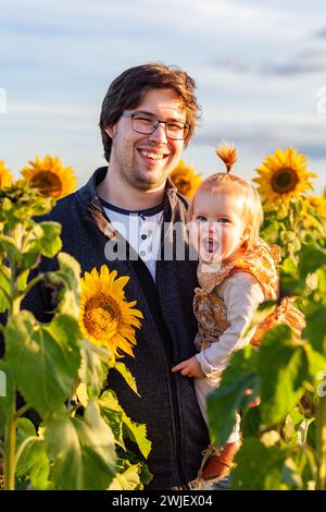 Portrait de jeune papa et jeune fille heureuse dans le champ de tournesol Banque D'Images