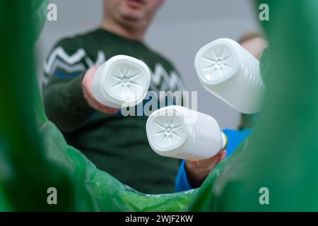 Vue à angle bas une boîte de recyclage de bouteilles en plastique de tri familial à la maison. Élimination des produits de bouteilles de lait. Banque D'Images