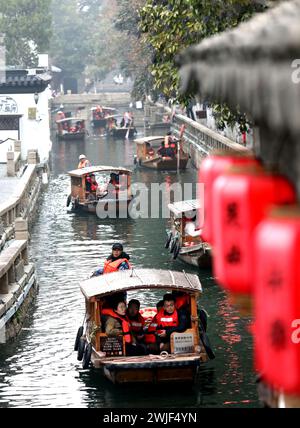 Pékin, province chinoise du Jiangsu. 15 février 2024. Les touristes visitent la route de Pingjiang en bateau à Suzhou, dans la province du Jiangsu de l'est de la Chine, le 15 février 2024. De plus en plus de Chinois choisissent aujourd'hui de partir en voyage pendant le Festival du printemps pour découvrir différentes cultures et l'atmosphère lunaire du nouvel an. Crédit : Hang Xingwei/Xinhua/Alamy Live News Banque D'Images