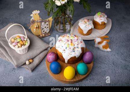 Kulich de Pâques avec des fruits confits en glaçage blanc avec des saupoudrages colorés et des œufs peints. Pâtisserie traditionnelle de Pâques. Vacances de Pâques. Gros plan, sélectionnez Banque D'Images