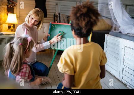 Éducation, concept de maternelle. Groupe d'enfants d'âge préscolaire à l'écoute de l'enseignant. Banque D'Images