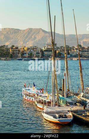 Bateaux à moteur colorés et felouques sur la rive du Nil à Louxor, Egypte Banque D'Images