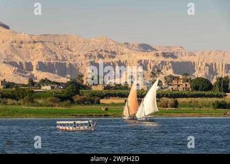 Bateaux à voile traditionnels felouques égyptiens sur le Nil, montagnes thébaines en arrière-plan à Louxor, Egypte Banque D'Images