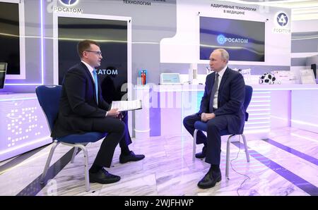 Moscou, Russie. 15 février 2024. Le président russe Vladimir Poutine est interviewé par Pavel Zarubin, journaliste de télévision de Rossiya One, à gauche, lors du Forum sur les technologies du futur au World Trade Centre de Moscou, le 14 février 2024 à Moscou, en Russie. Le Forum des technologies du futur présente les progrès scientifiques et médicaux nationaux. Crédit : Alexander Kazakov/Kremlin Pool/Alamy Live News Banque D'Images