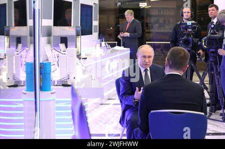 Moscou, Russie. 15 février 2024. Le président russe Vladimir Poutine est interviewé par Pavel Zarubin, journaliste de Rossiya One, à droite, lors du Forum sur les technologies du futur au World Trade Centre de Moscou, le 14 février 2024 à Moscou, en Russie. Le Forum des technologies du futur présente les progrès scientifiques et médicaux nationaux. Crédit : Alexander Kazakov/Kremlin Pool/Alamy Live News Banque D'Images