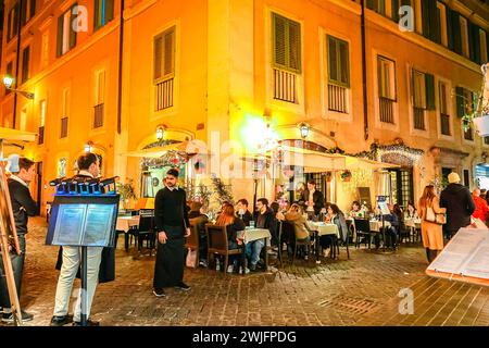 Italie, Rome - 26 novembre 2023 : vieille rue confortable illuminée la nuit. Architecture de Rome. Cafés et restaurants dans les lumières de Noël, Italie Banque D'Images