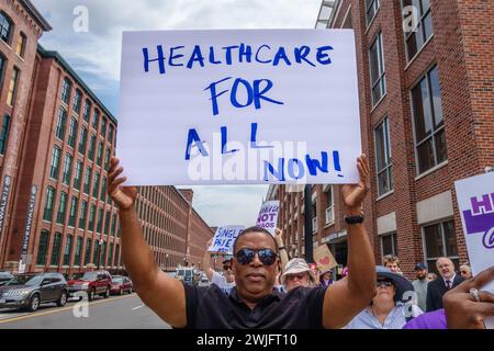 LAWRENCE, ma, États-Unis – 20 JUILLET 2017 : un homme hispanique brandit une pancarte de protestation indiquant « Healthcare for All ». Banque D'Images