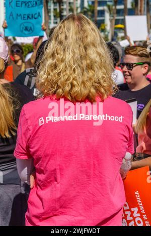 Sarasota, Floride, États-Unis -24 mars 2018 -une manifestante vue de derrière portant une chemise rose Planned Parenthood. Banque D'Images